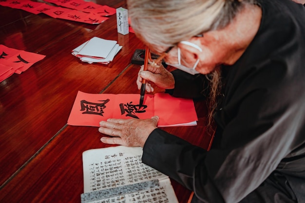 Vietnamese scholar writes calligraphy at Long Son Calligraphy festival is a popular tradition during Tet holiday Writing couplets for Spring Festival new year