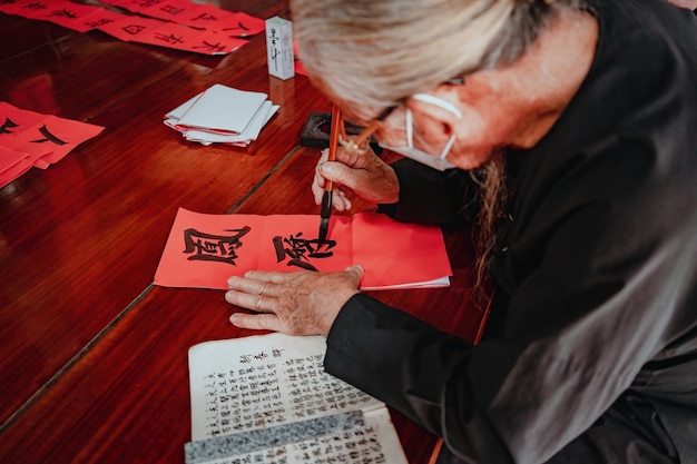 베트남 학자는 Long Son Calligraphy 축제에서 서예를 씁니다. Tet 휴일 동안 인기 있는 전통입니다.