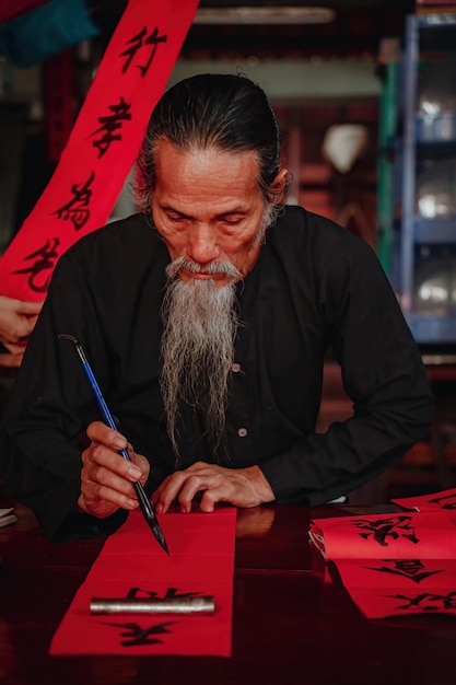 vietnamese scholar writes calligraphy at long son calligraphy festival is a popular tradition during tet holiday writing couplets for spring festival new year