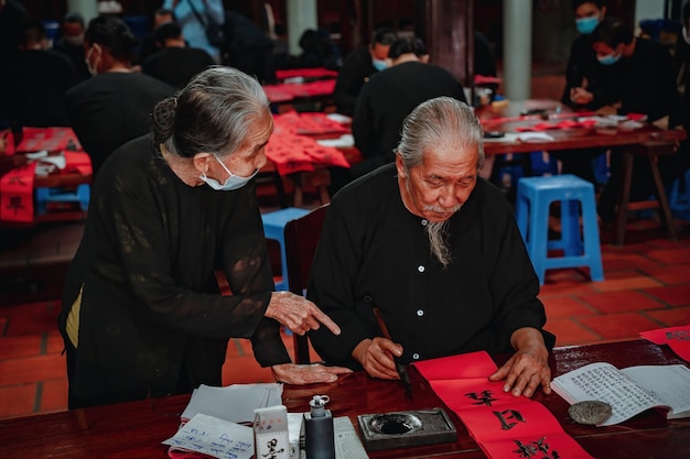 베트남 학자는 Long Son Calligraphy 축제에서 서예를 씁니다. Tet 휴일 동안 인기 있는 전통입니다.