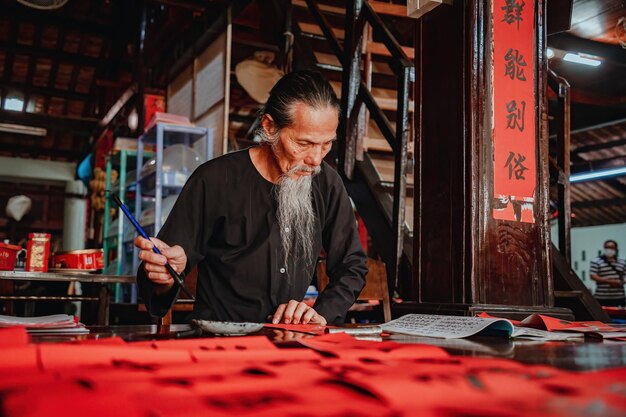 Vietnamese scholar writes calligraphy at Long Son Calligraphy festival is a popular tradition during Tet holiday Writing couplets for Spring Festival new year