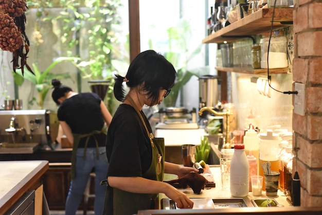 Vietnamese serveerster maakt een bestelling klaar in een coffeeshop