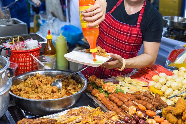 写真 ベトナムのナイトマーケットでチリ入りのプラスチックの箱に鶏の足を提供するベトナム人女性