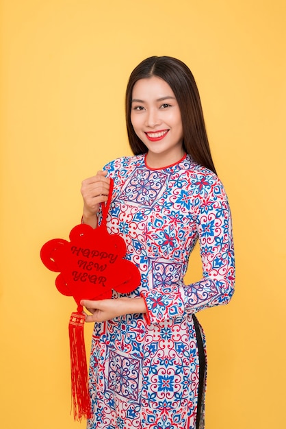 Vietnamese woman traditional festival costume Ao Dai holding attributes. Text mean Happiness.