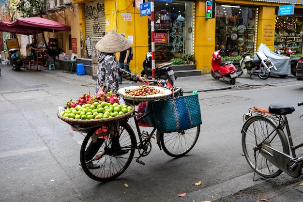 Vietnamita vendiendo frutas frescas en las calles del casco antiguo de 하노이