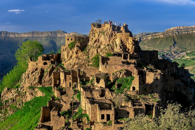 View of the abandoned village of Gamsutl on top of a mountain in Dagestan with tourists among the ruins