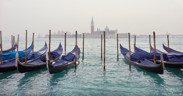 Вид на лагуну в Венеции с гондолами в туманный день