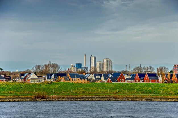 View across the river spui towards suburban eighbourhoods of spijkenisse behind the dike