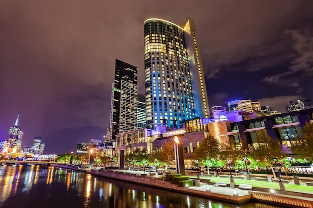 A view across the Yarra river and the landmark of Melbourne downtown under the cloudy sky.