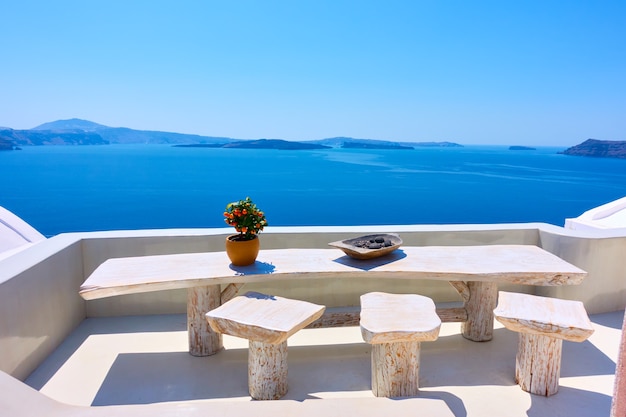 View of the Aegean sea from Santorini island with table and  seats in the foreground, Greece. Greek landscape. Travel destination