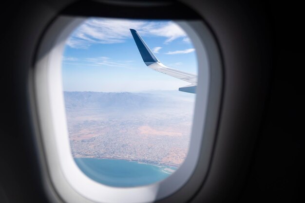 View of aircraft wing and clouds through the porthole