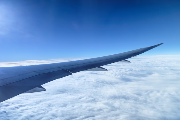 Photo view of aircraft wing with cloud on blue sky