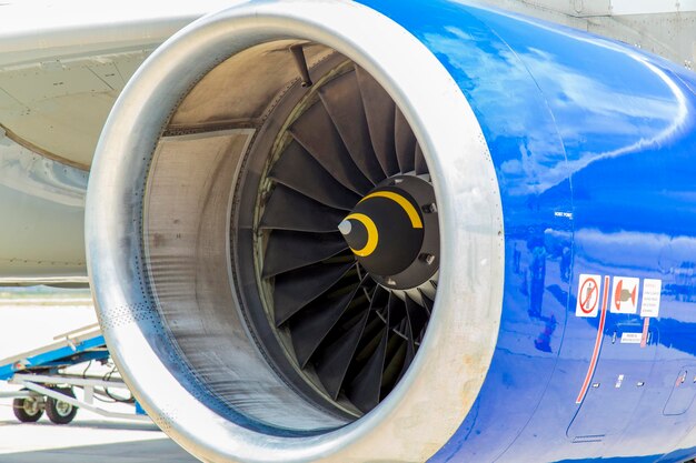 View of Airplane engine during the airplane boarding image includes harsh shadows due to sunny day