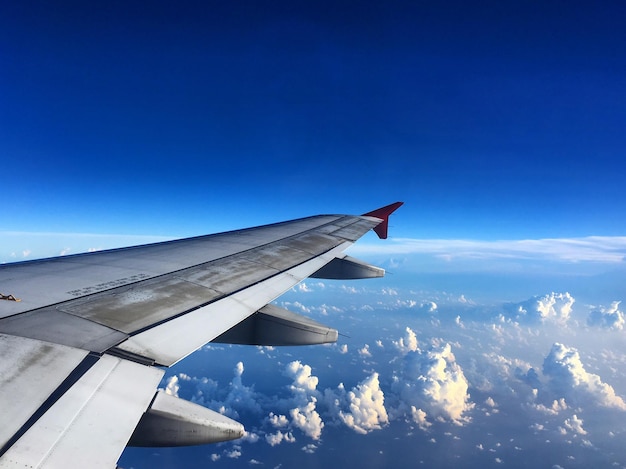 View of airplane wing against cloudy sky