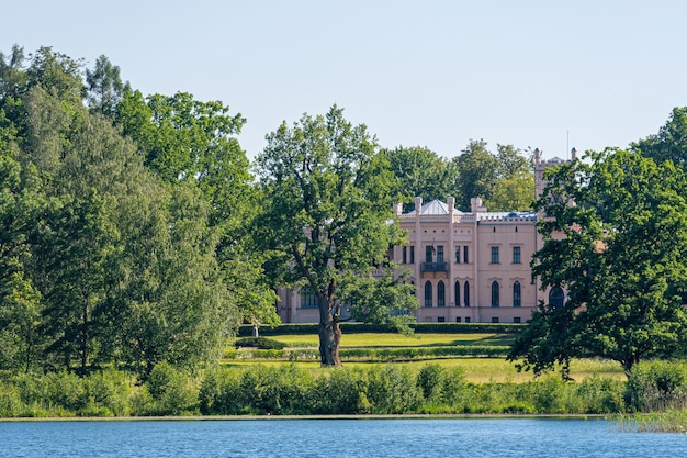 View of Aluksne New Castle from the lake on a sunny summer day