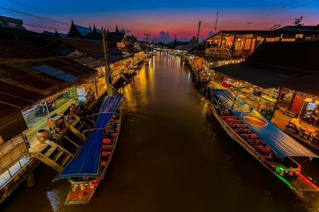 Vista delle città del mercato galleggiante di amphawa e i turisti camminano facendo shopping mangiano e scattano foto in giro