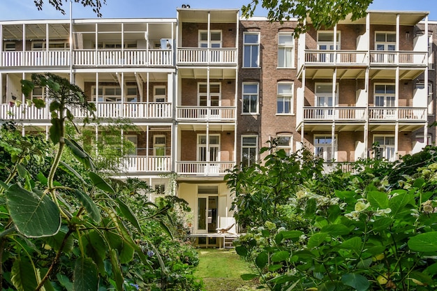 Photo a view of an apartment building with bushes in front