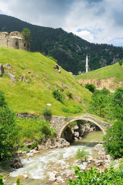 View of a arch bridge with minaret in the old greek church. Giresun - Turkey