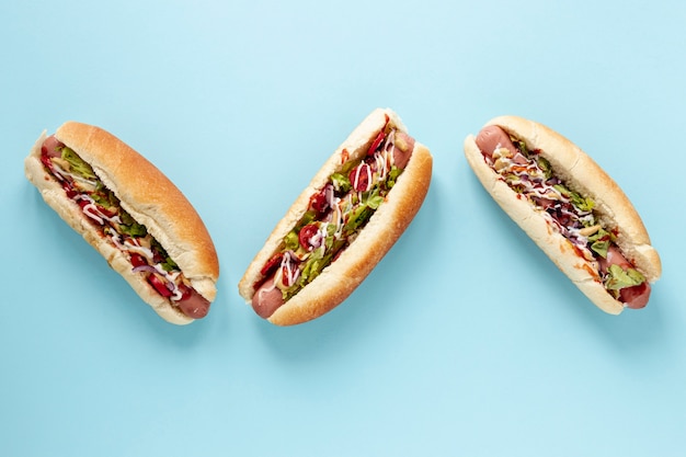 Photo above view arrangement with hot dogs and blue background