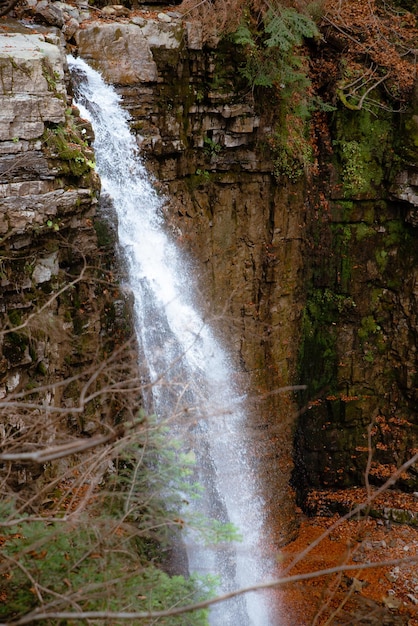 View of autumn waterfall in dip forest