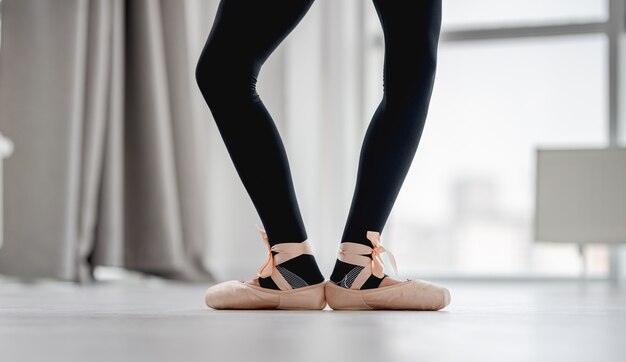 View of ballerina legs staying in first position during dance class in choreography studio