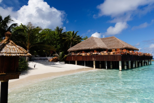 View to a bar on an island with clouds and beach