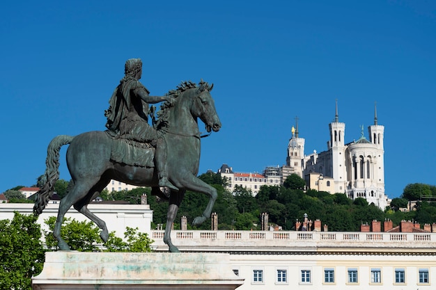 Vista della basilica di notre dame de fourviere e la statua di luigi xiv