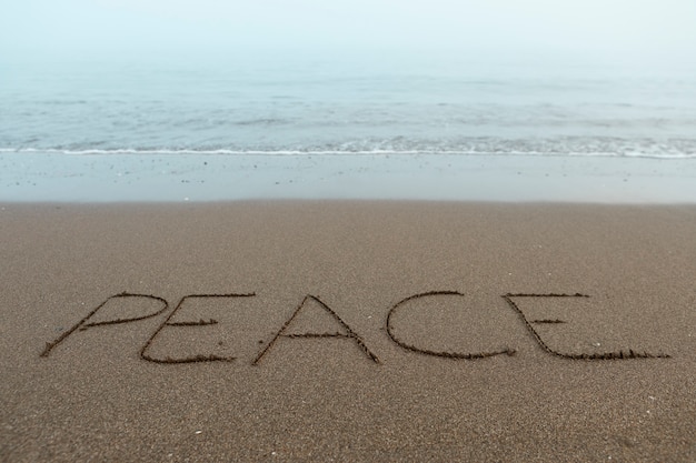 Foto vista della sabbia della spiaggia in estate con un messaggio scritto su di essa