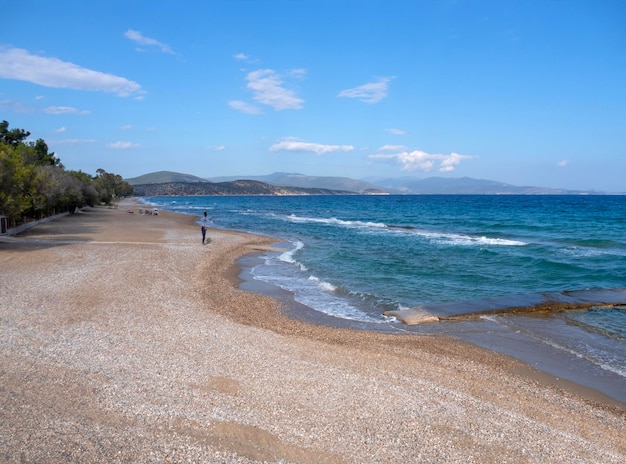 그리스 의 펠로폰네소스 섬 의 휴양 도시 톨로 의 관광객 들 과 함께 해변 과 바다 를 바라보는 모습