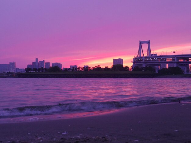 View of beach with city in background during sunset