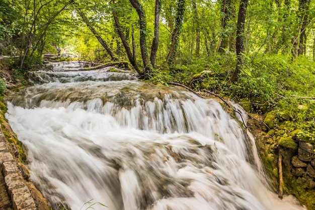 View of the beautiful picturesque waterfalls on Plitvice Lakes Rocks and green trees around lakes