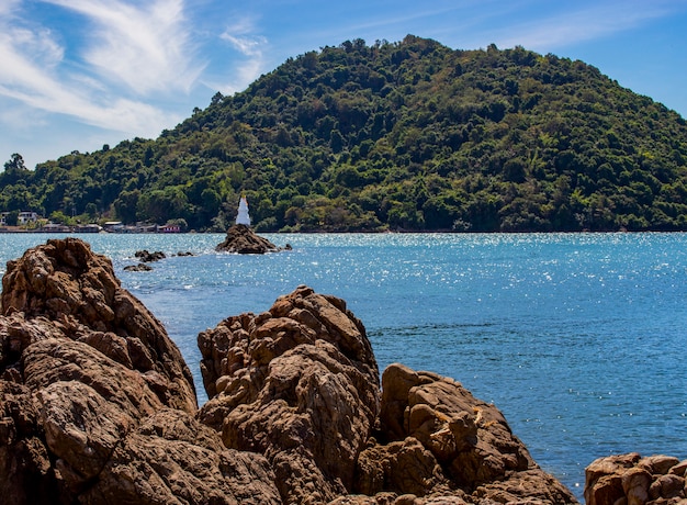 Vista di grande roccia e pagoda in mare. chedi in mezzo all'acqua.