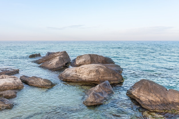 View of blue sea waves at rocky beach. Horizon line. Caspian Sea, sandstone coast