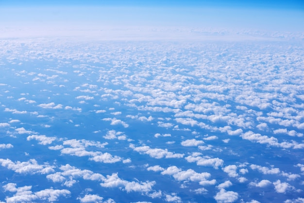 飛行機の窓から雲の上の青い空の眺め