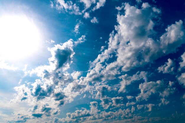 Vista del cielo azzurro e grandi nuvole bianche sotto i raggi del sole. sfondo del cielo. panorama del cielo con nuvole bianche e scure