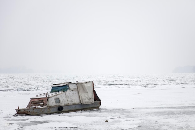冬の凍った氷の川でボートで見る