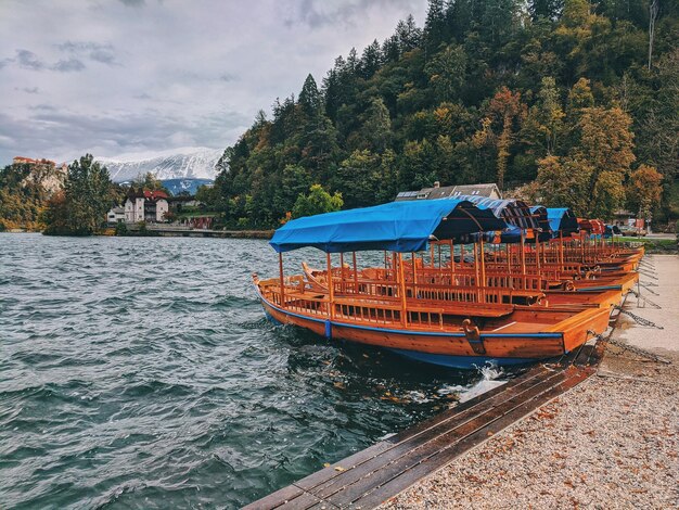 Photo view of boat in lake bled against autumn sky