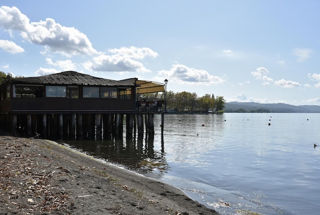 View of Bolsena Lake A typical restaurant on wooden pilework in the background Bolsena Lazio Italy