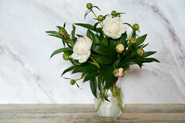 ウィンドウの花瓶に立っている白い牡丹の花束のビュー コンセプトの背景の花の休日