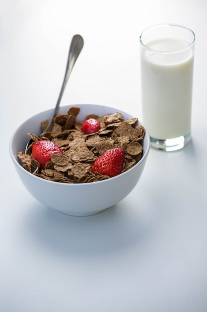 View of a bowl of cereals and glass of milk on a table