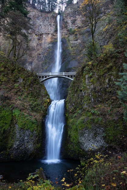 View of a bridge going over a river with Multnomah Falls in the background