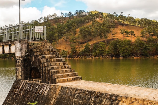 Photo view of bridge over river against cloudy sky