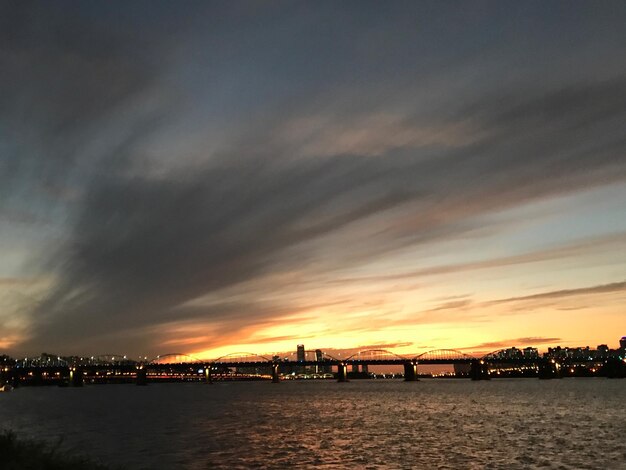 View of bridge over river against cloudy sky