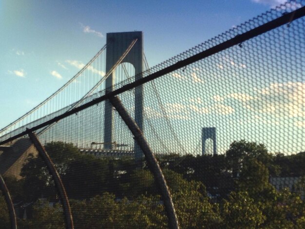 View of bridge through chainlink fence