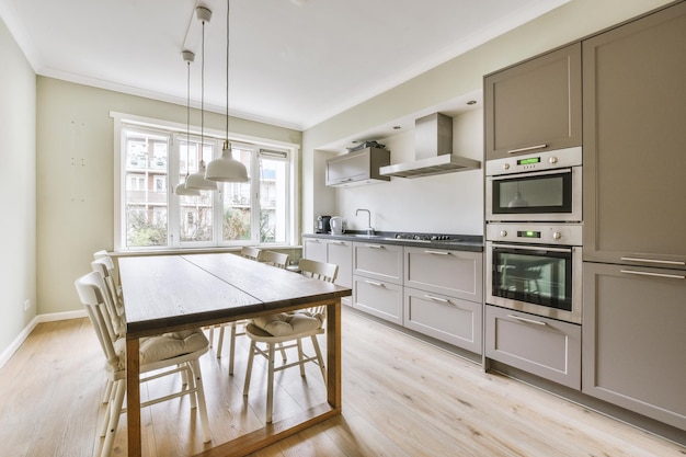 View of bright kitchen from with table and chairs in the centre