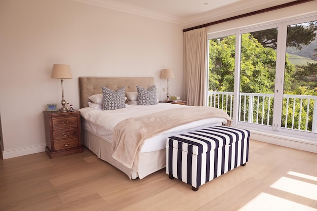 View of a bright modern bedroom interior with a garden view. Self isolating and social distancing in quarantine lockdown during coronavirus covid 19 epidemic.