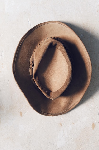 Photo view of brown suede hat from above on rustic white background