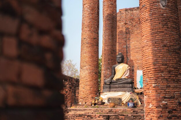 Foto vista di una statua di buddha contro un muro di mattoni