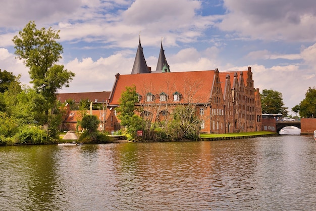 Photo view of buildings by river against cloudy sky