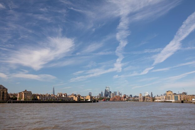 View of buildings by sea against cloudy sky